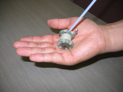 Fig. 2 Miniature pulsed magnet removed from the device.  The magnet can generate a high magnetic field of 40 T, approximately one millionfold higher than geomagnetic field, despite its size being smaller than the palm of a hand.