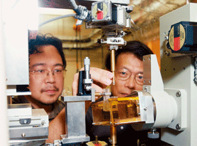 Dr. Yagi (right) and Dr. Uesugi (left) setting a sample onto the phase-difference X-ray CT system.