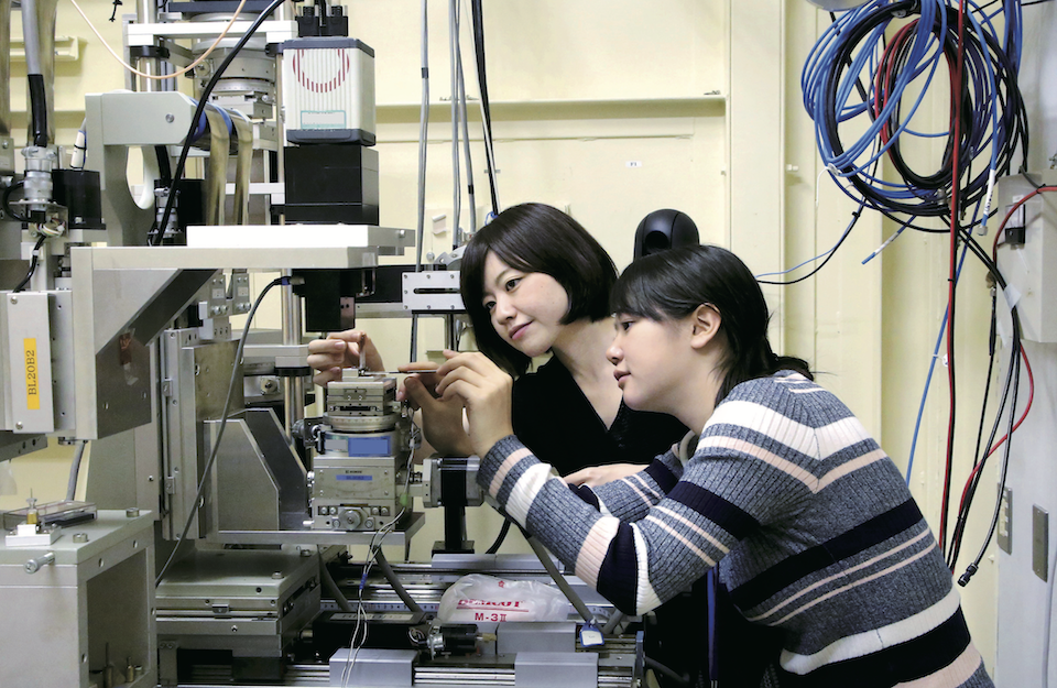 分析試料をフォルダに取り付ける水谷さん（左）と西村さん（右）